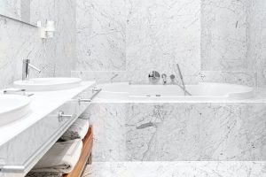 beautiful interior of a modern white marble hotel batroom with bathtube and towels